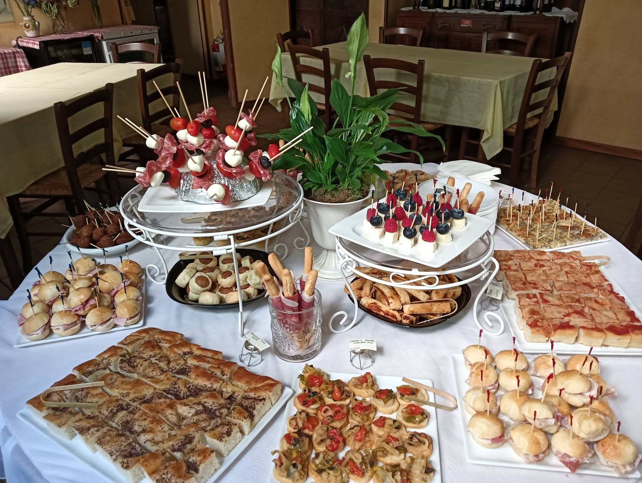 Buffet con spiedini di mozzarella, focaccia, pizzette e paninetti al prosciutto nella sala del Ristorante La Ghironda